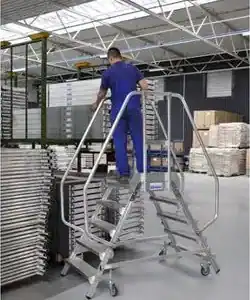 Dobbel plattformtrapp i aluminium i bruk med rekkverk og hjul